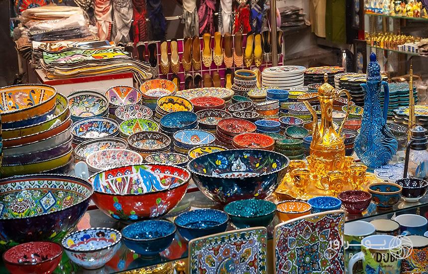 نمایی از یک فروشگاه صنایع‌دستی در دبی که شامل ظرف‌های سفالی رنگی است.